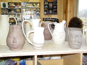 Plaster cast faces on cups and vases